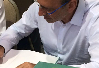 Michel Farah dando autógrafo no lançamento do livro de OCT.
